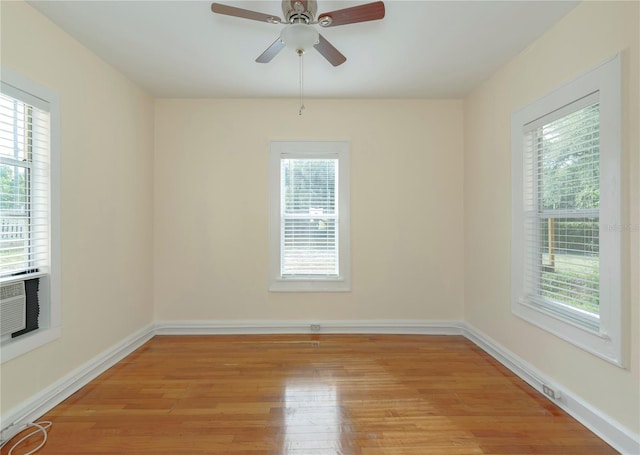 spare room with a ceiling fan, light wood-style flooring, and baseboards
