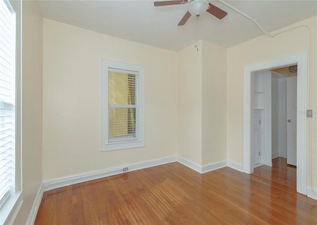 spare room featuring a ceiling fan, baseboards, and wood finished floors