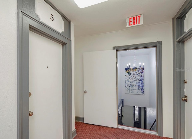 corridor with a chandelier and carpet
