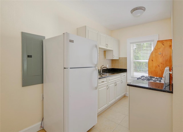kitchen with a sink, backsplash, freestanding refrigerator, electric panel, and dark countertops