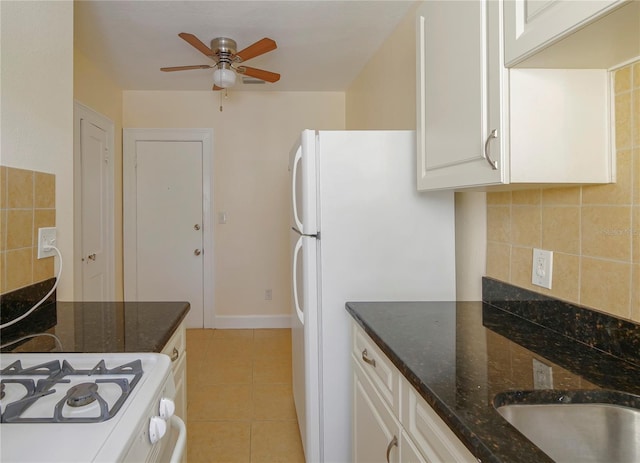 kitchen featuring white cabinets, dark stone counters, decorative backsplash, and light tile patterned flooring