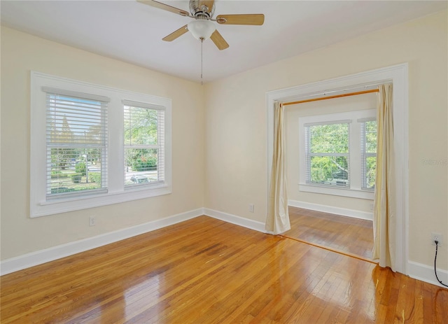 spare room with a ceiling fan, baseboards, and light wood finished floors