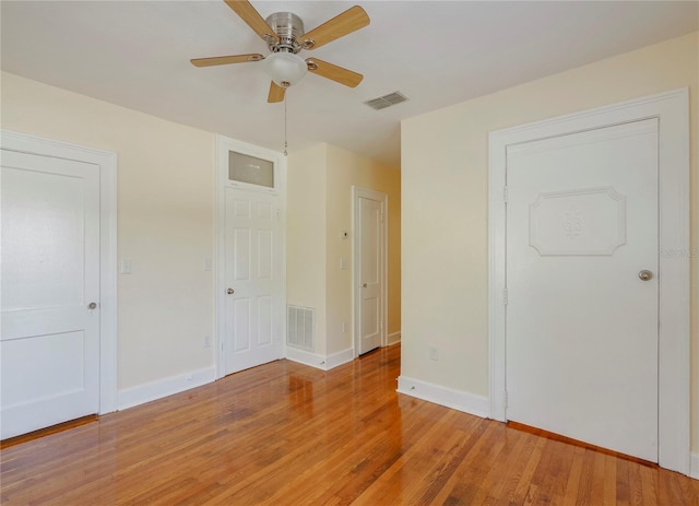 unfurnished bedroom with baseboards, a ceiling fan, visible vents, and light wood-style floors