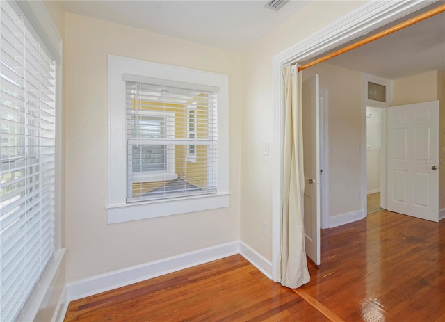 corridor featuring baseboards and wood finished floors
