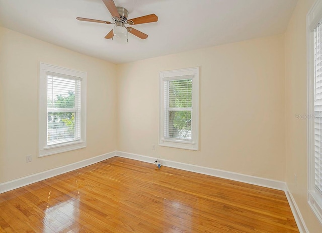 spare room featuring light wood-style floors, baseboards, and a ceiling fan