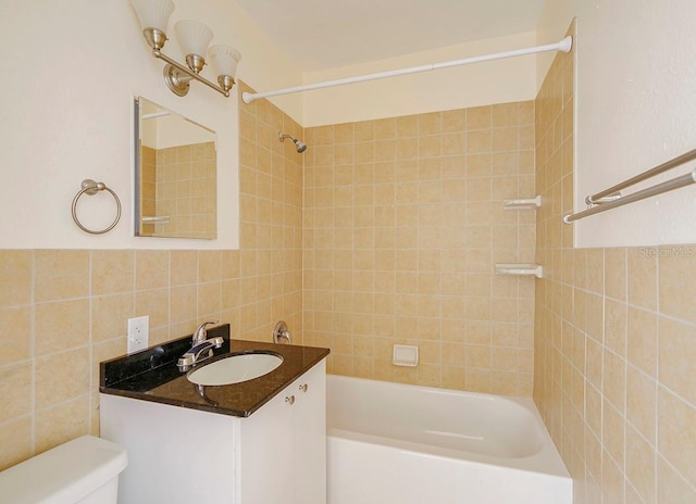 bathroom featuring bathing tub / shower combination, vanity, toilet, and tile walls