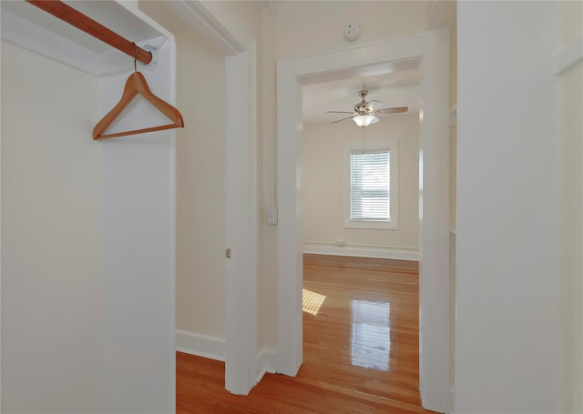 corridor featuring baseboards and wood finished floors