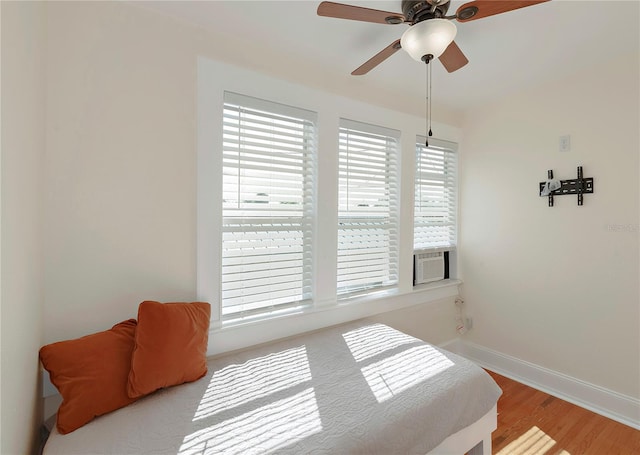 bedroom featuring ceiling fan, baseboards, and wood finished floors