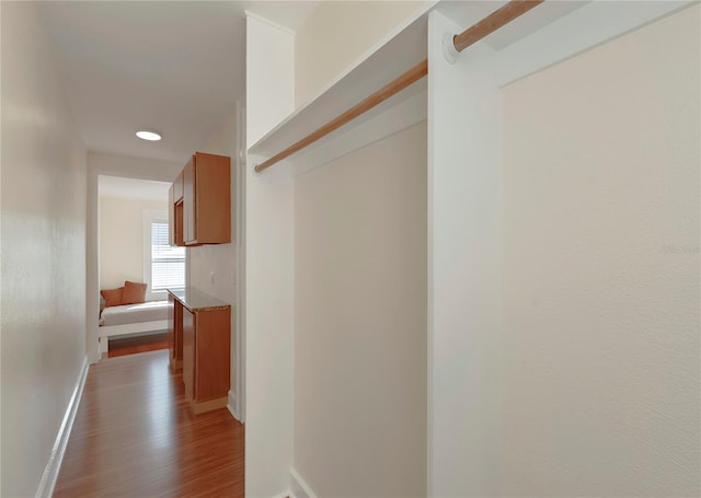 hallway with baseboards and wood finished floors