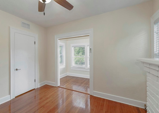 doorway to outside featuring a ceiling fan, baseboards, visible vents, and wood finished floors