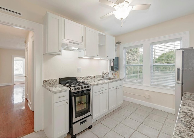 kitchen featuring stainless steel appliances, visible vents, white cabinets, a sink, and under cabinet range hood