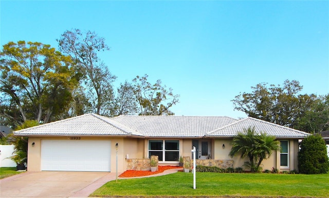 ranch-style house with a garage, concrete driveway, a tiled roof, and a front lawn