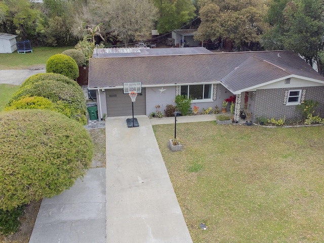 view of front of property with driveway, roof with shingles, and a front lawn