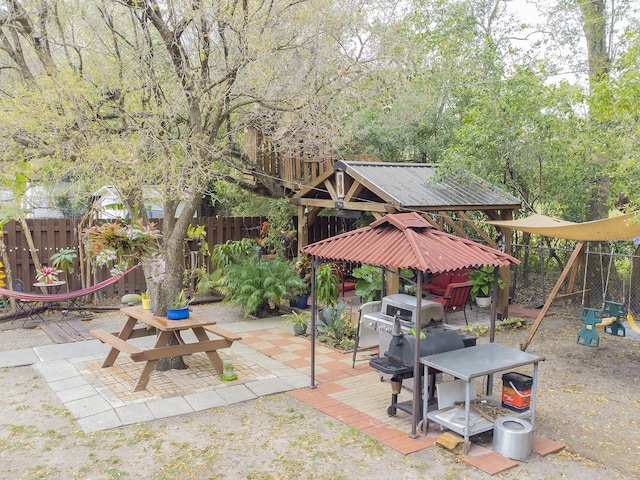 view of patio with a gazebo, a playground, and fence