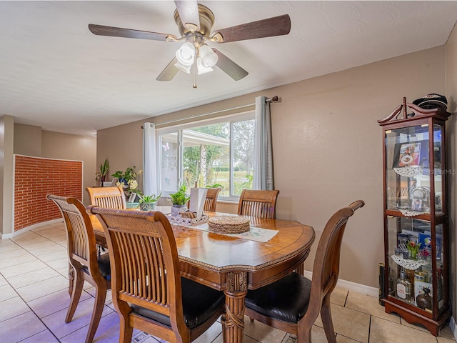 dining space featuring light tile patterned floors, a ceiling fan, and baseboards