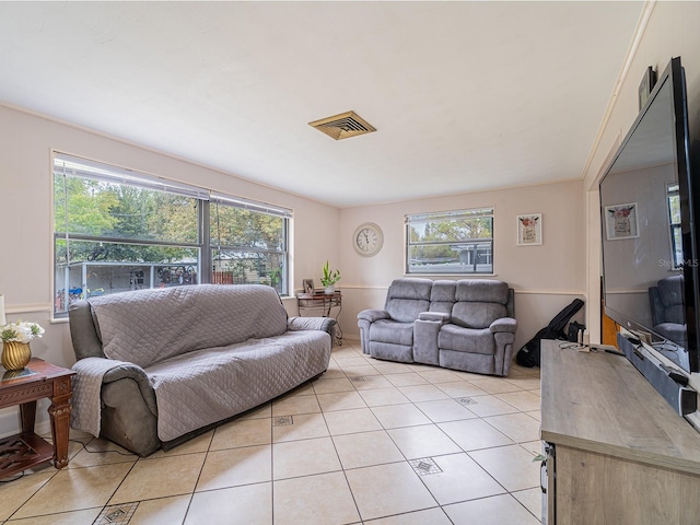 living room with light tile patterned floors, visible vents, and plenty of natural light