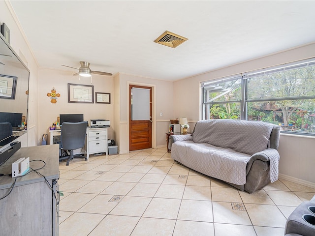 living area with visible vents, ornamental molding, a ceiling fan, light tile patterned flooring, and baseboards