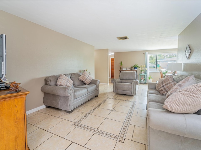 living area with light tile patterned floors, visible vents, and baseboards