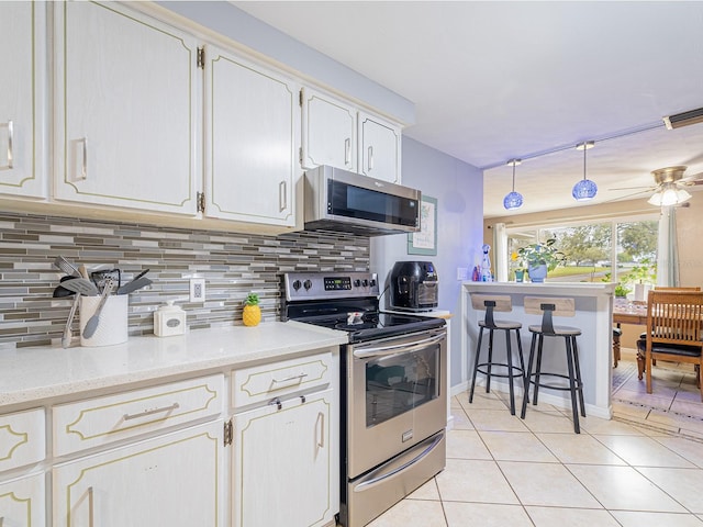 kitchen featuring light tile patterned floors, a ceiling fan, visible vents, decorative backsplash, and appliances with stainless steel finishes