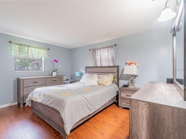 bedroom featuring light wood-style flooring and baseboards