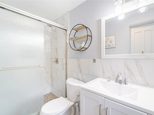 bathroom with vanity, toilet, tile walls, and a shower stall