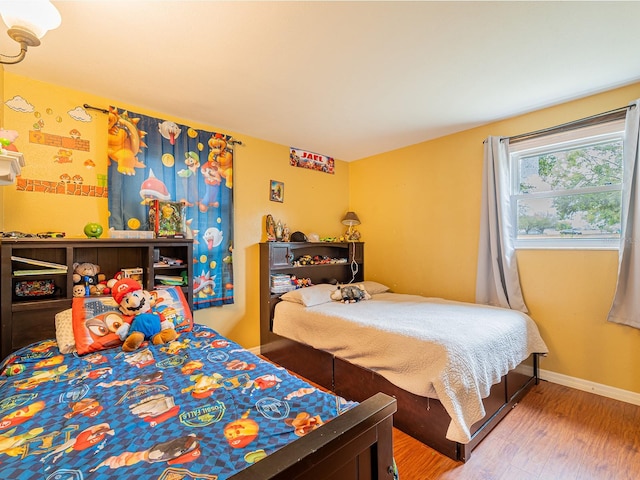 bedroom featuring baseboards and wood finished floors