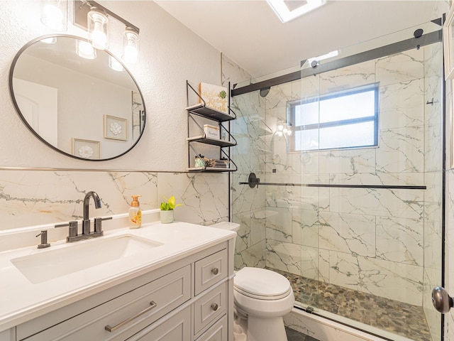 full bath with vanity, toilet, a textured wall, and a marble finish shower