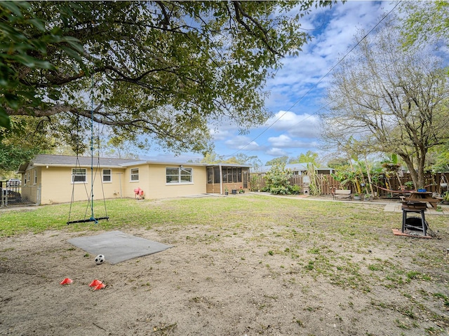 view of yard with a sunroom and fence