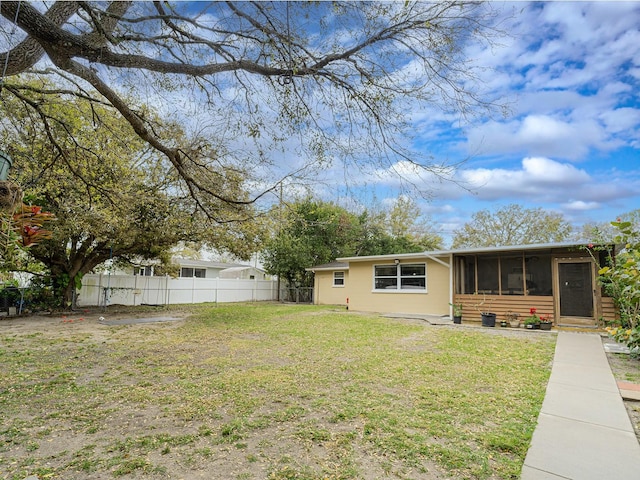 view of yard featuring fence and a sunroom