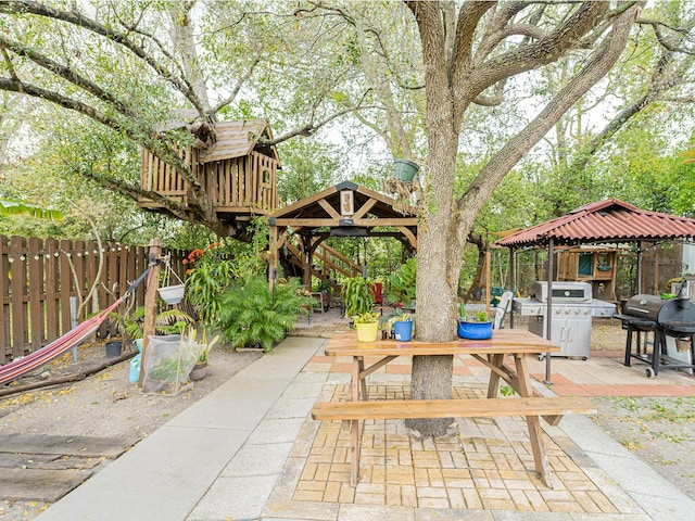 view of patio / terrace featuring a gazebo, area for grilling, outdoor dining area, and fence