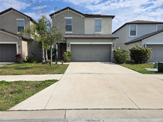 traditional-style house with a garage, concrete driveway, and stucco siding