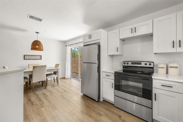 kitchen with light wood finished floors, visible vents, decorative backsplash, stainless steel appliances, and light countertops