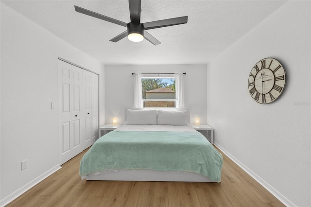 bedroom with a closet, baseboards, and wood finished floors