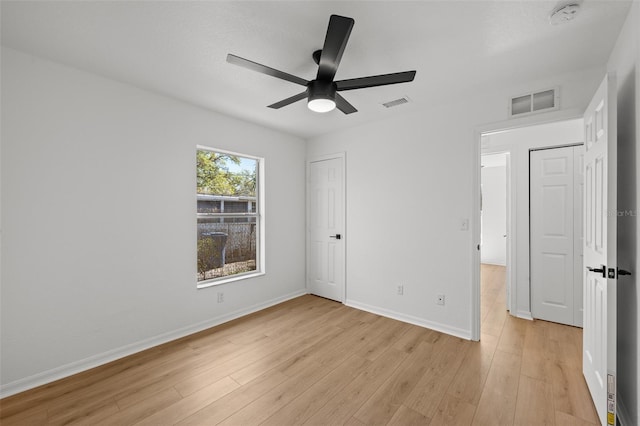 unfurnished bedroom featuring baseboards, visible vents, and light wood finished floors