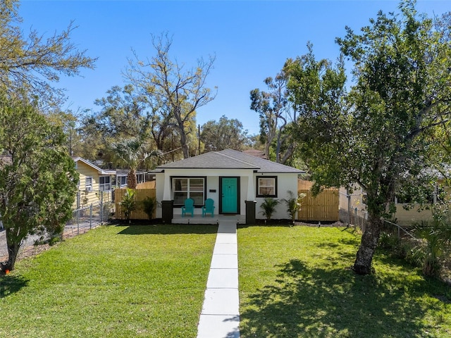 view of front of house featuring a front yard, fence, and stucco siding