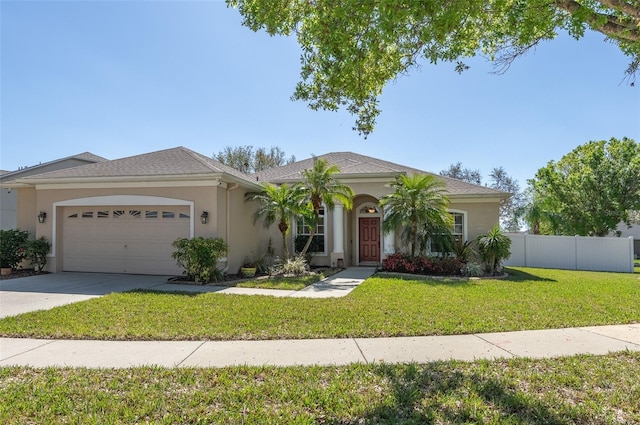 view of front facade featuring driveway, stucco siding, fence, and a front yard