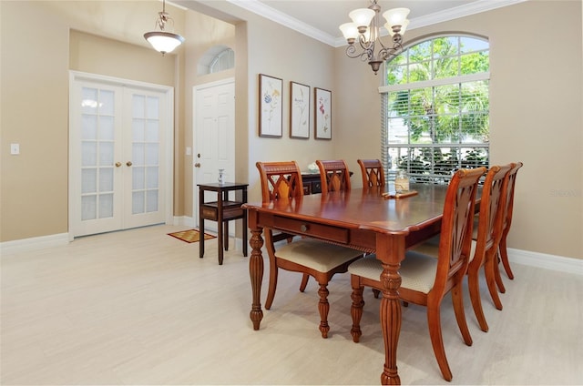 dining space featuring french doors, an inviting chandelier, ornamental molding, light wood-type flooring, and baseboards