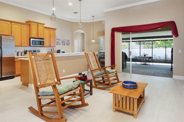 interior space with arched walkways, pendant lighting, decorative backsplash, appliances with stainless steel finishes, and ornamental molding