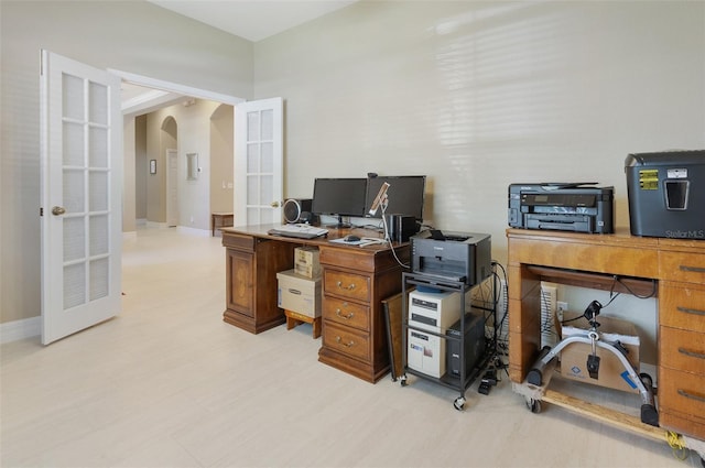 home office with arched walkways, french doors, and baseboards