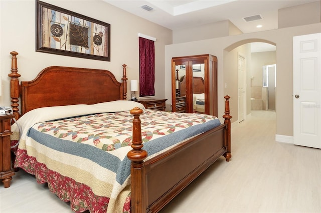 bedroom featuring arched walkways, visible vents, light wood finished floors, and recessed lighting