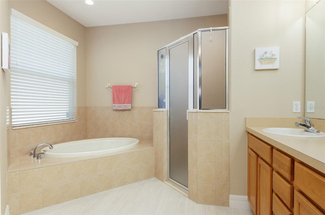 bathroom featuring a stall shower, a garden tub, and vanity