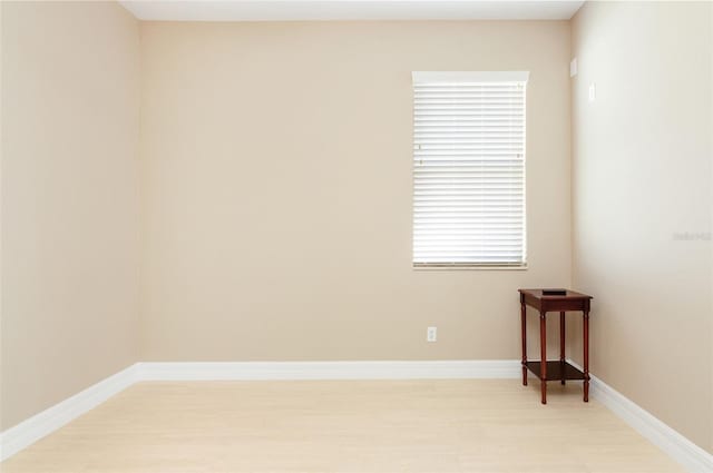 empty room with light wood finished floors and baseboards