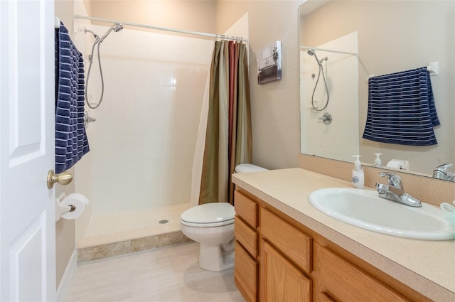 bathroom with tiled shower, vanity, and toilet