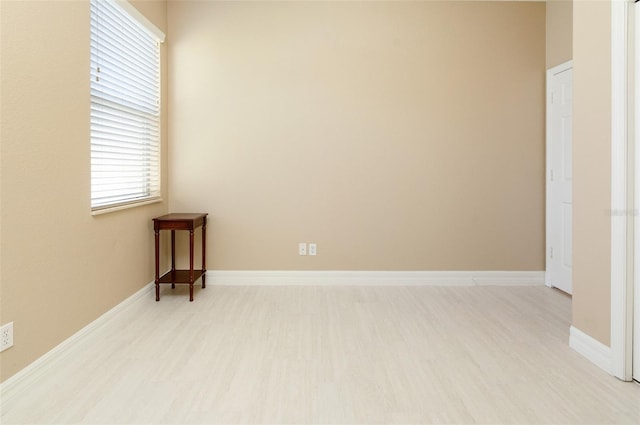 empty room with light wood-style flooring and baseboards