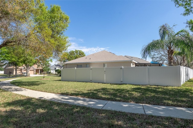 view of home's exterior featuring a yard, fence, and stucco siding