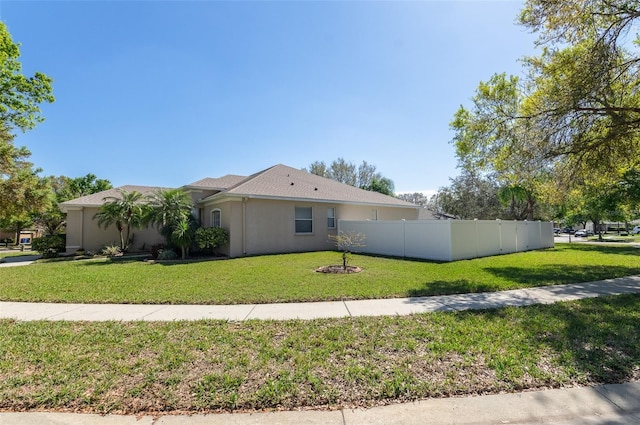 view of front of home with a garage, a front yard, fence, and stucco siding