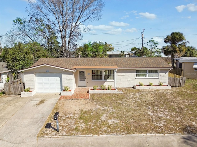 single story home featuring a shingled roof, concrete driveway, fence, and an attached garage