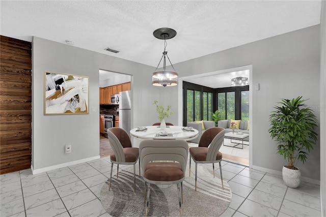 dining room with marble finish floor, visible vents, a notable chandelier, and baseboards