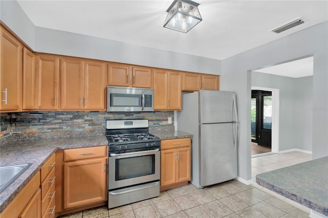 kitchen with light tile patterned floors, visible vents, baseboards, appliances with stainless steel finishes, and decorative backsplash