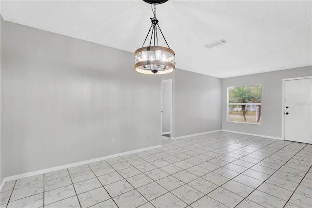 unfurnished room featuring baseboards and a chandelier